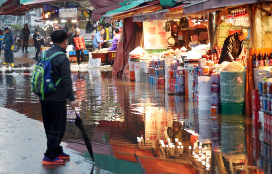 지구와 달이 가장 가까워지며 보름달이 가장 크게 보이는 '슈퍼문'이 전망된 14일 오후 인천시 남동구 소래포구 어시장에 바닷물이 차오르면서 하수관이 역류, 바닥에 물이 차오르고 있다. 해양수산부 국립해양조사원은 오는 15일과 16일 전국 곳곳에서 해수면의 높이와 조차가 역대 최고수준으로 높아질 것으로 전망했다.